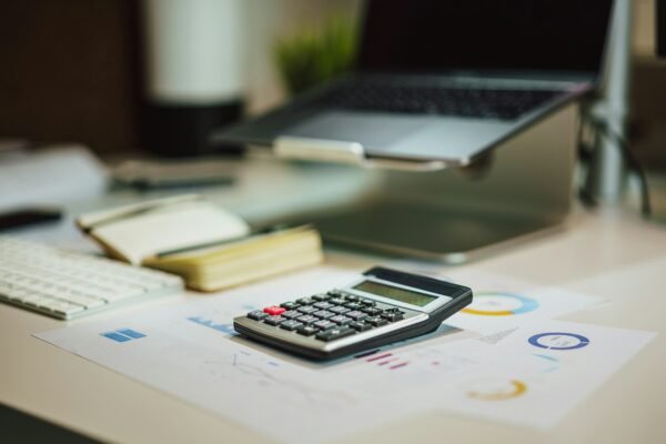 A calculator sitting on top of a table next to a laptop
