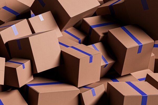 A large pile of brown cardboard boxes with blue tape