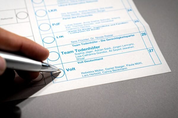 A person holding a pen over a piece of paper