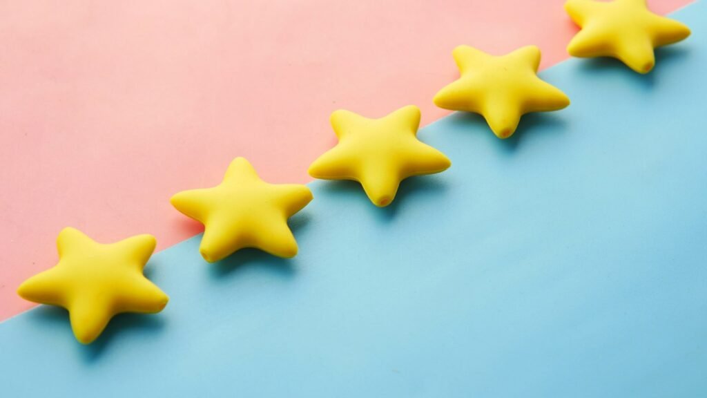 Trust signals: a row of yellow review stars on a blue and pink surface