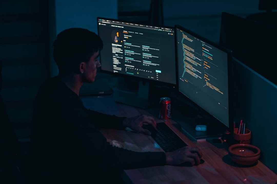 Man In Black Long Sleeve Shirt Using Computer