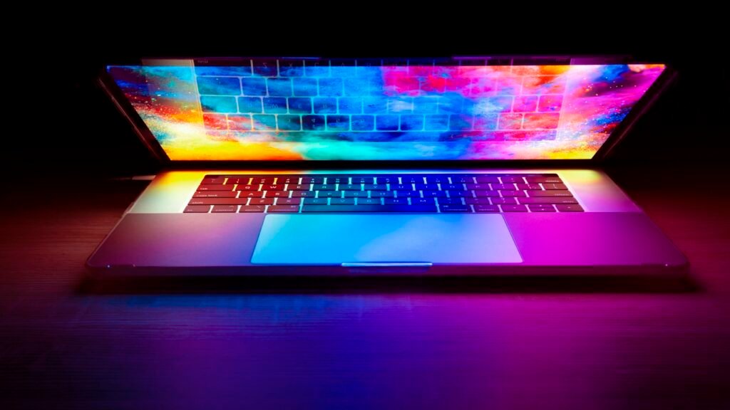 Website maintenance plan concept: a laptop glowing on a dark wooden desk