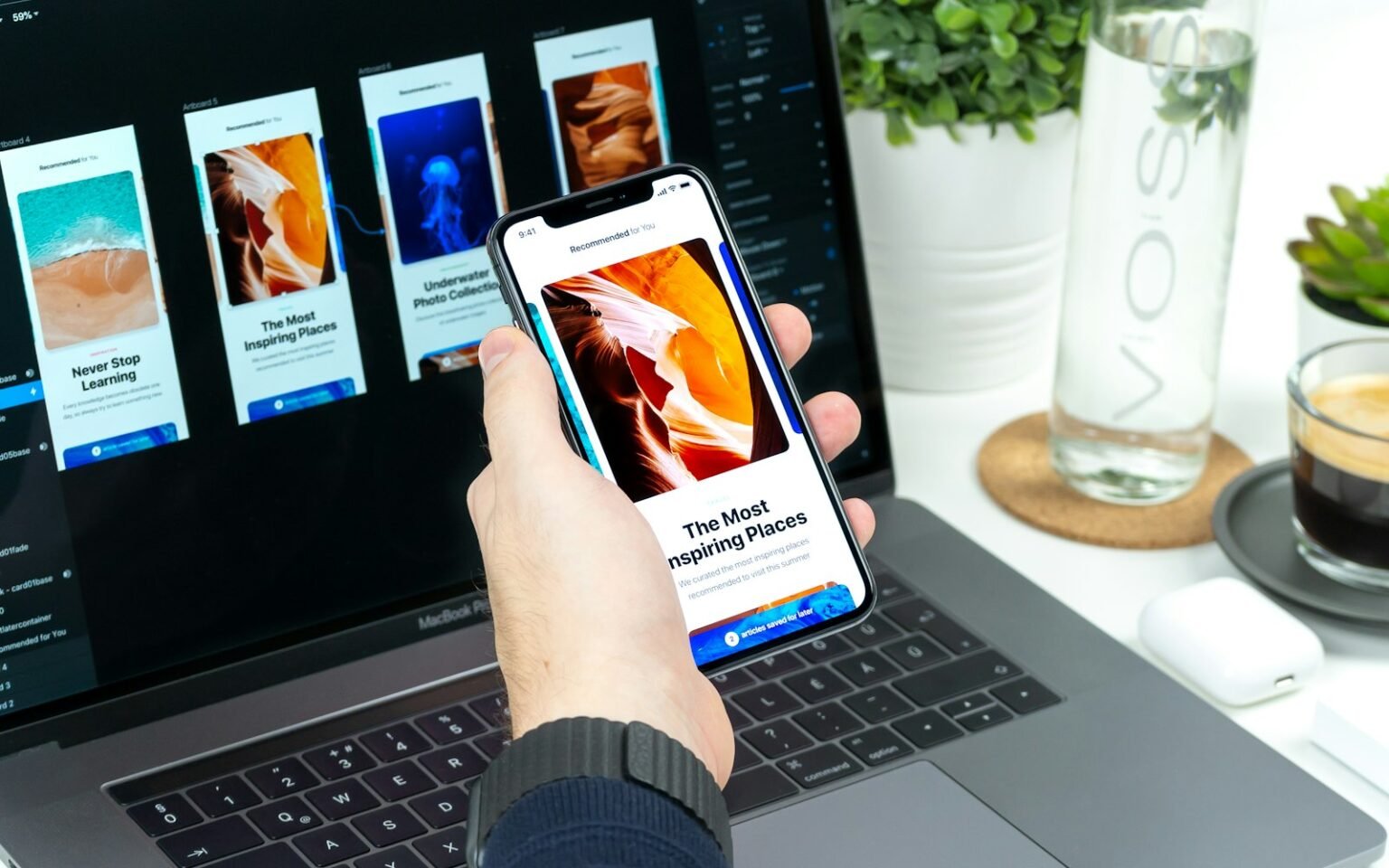 A mobile app design shown on a phone in front of a laptop