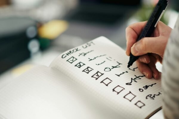 Pen ticking items off a printed checklist, the way to approach a legacy system modernisation