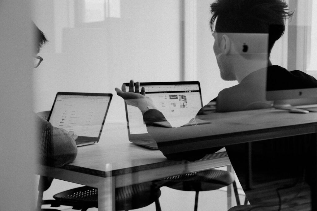 Colleagues working on laptops at a shared desk