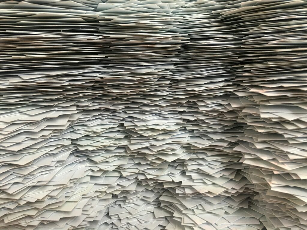 A huge, untidy pile of paper sheets stacked on top of each other