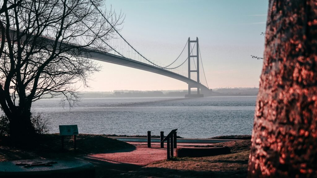 The Humber Bridge spanning the estuary, seen from the Hessle shore through bare winter trees