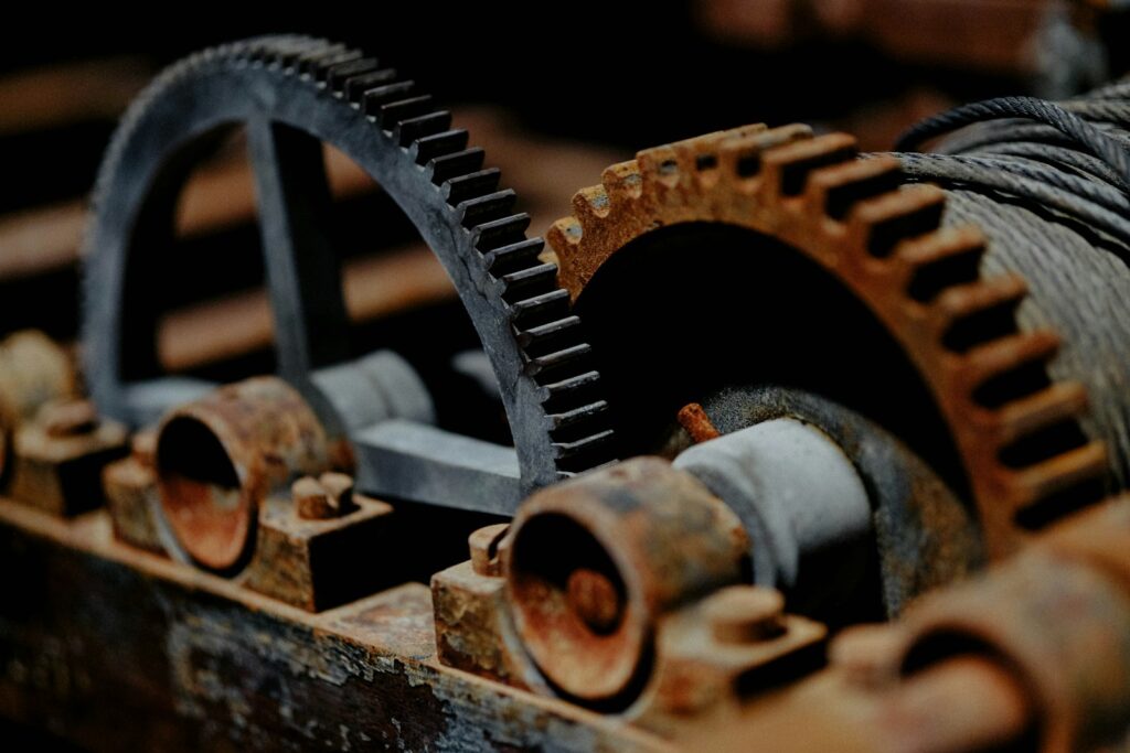 Close-up of old, rusty metal gear wheels meshing together