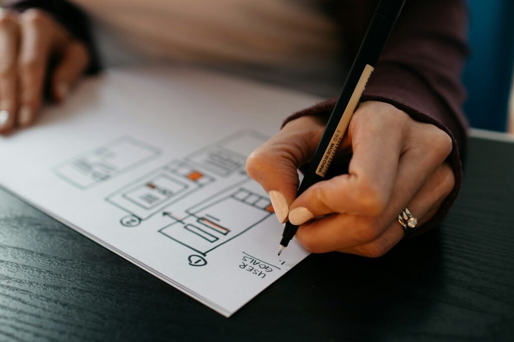 A designer sketching UX wireframes on paper